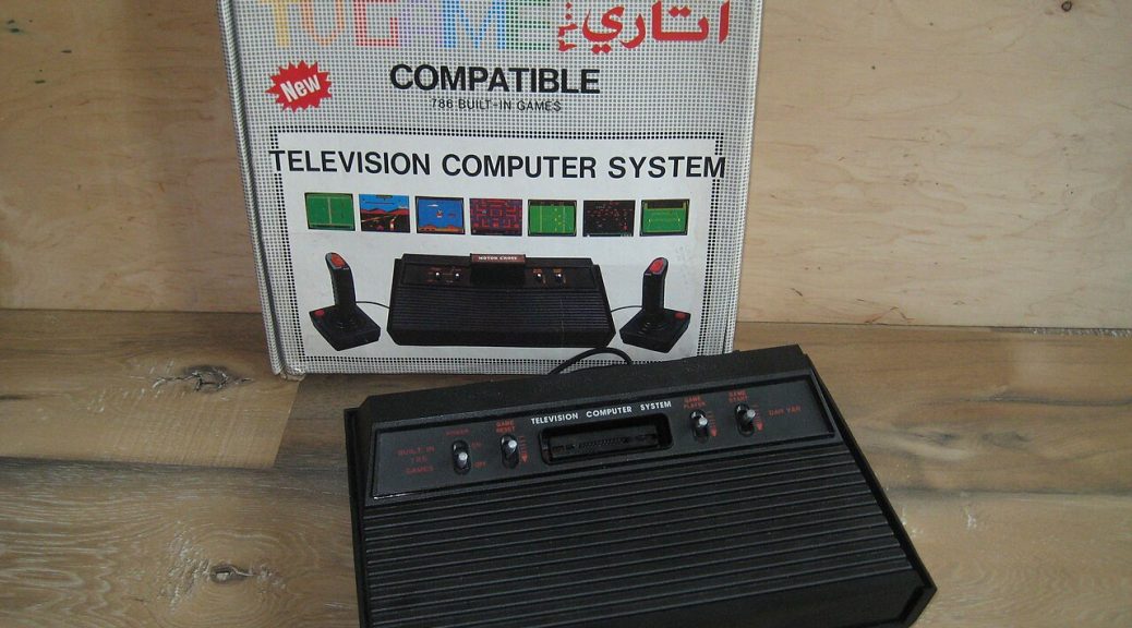 Czarny klon konsoli Atari 2600 z wbudowanymi grami, obok pudełko z napisem Television Computer System